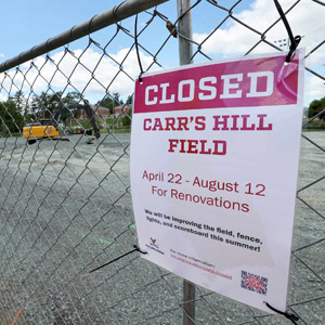 A closed for construction sign on a chain-link fence for Carr's Hill Fields